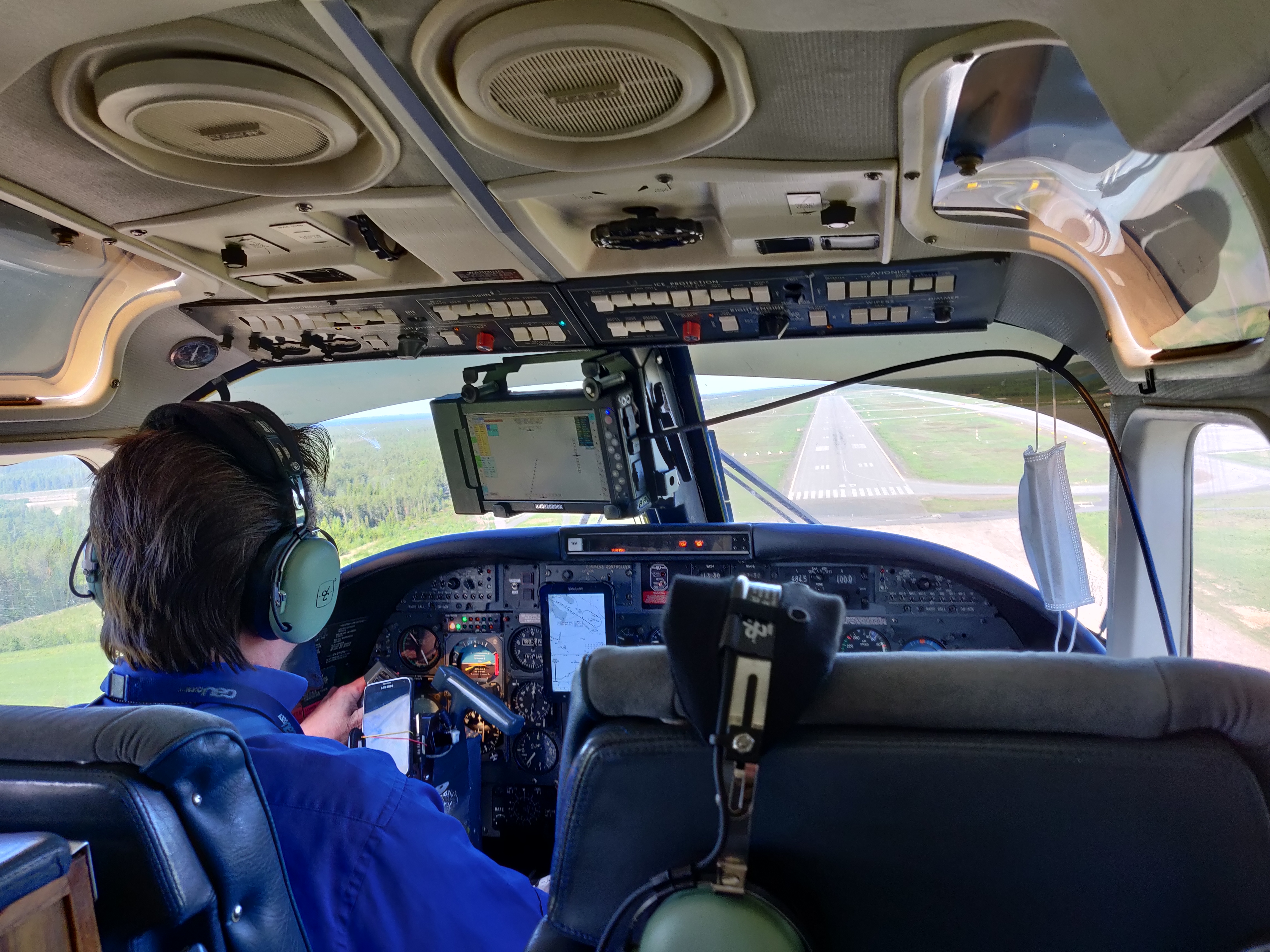 En bild från insidan av flygplanet. På bilden syns en person i cockpit.