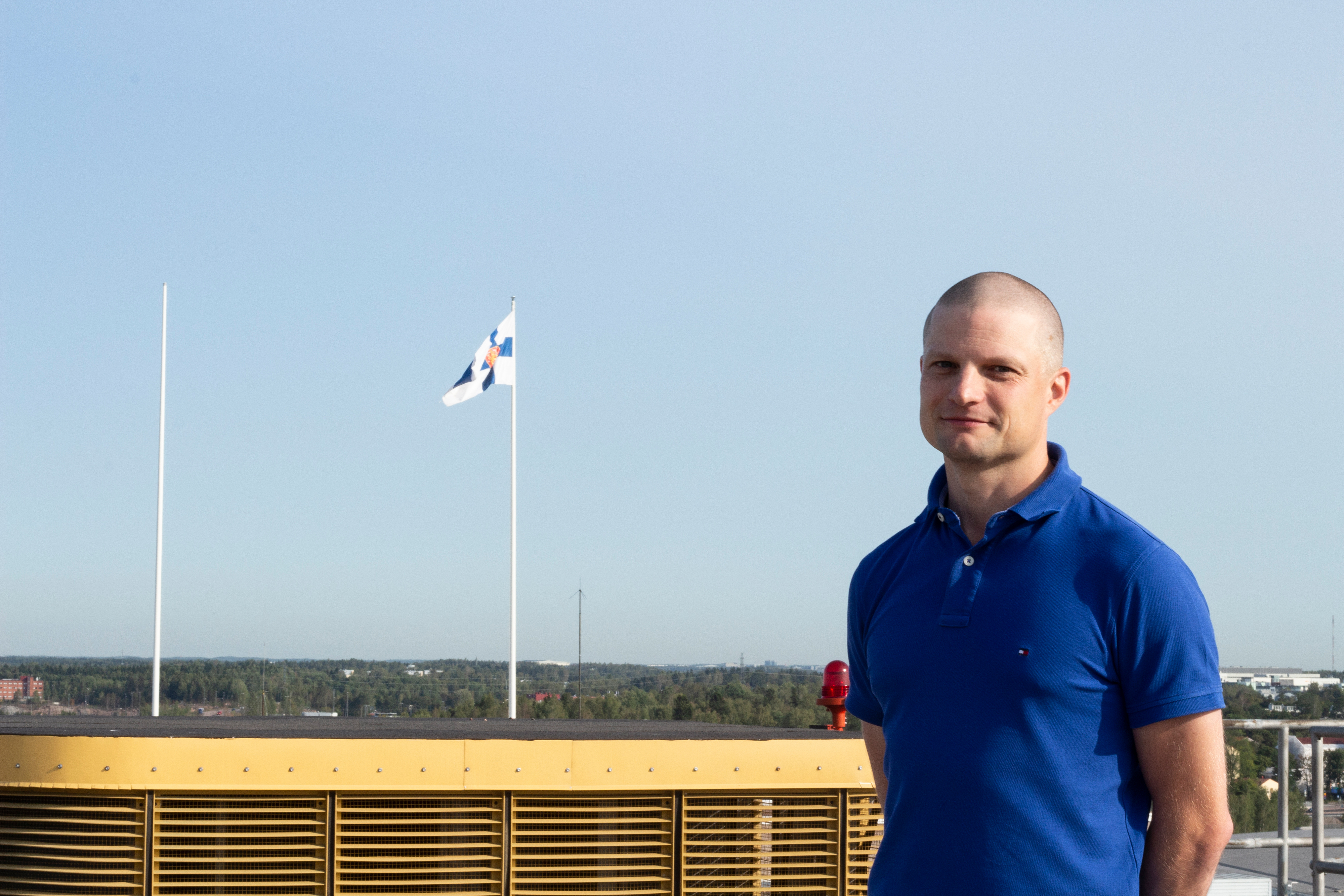 Projektipäällikkö Juha Kareinen hymyilee ulkona aurinkoisessa säässä.