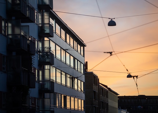 Kerrostalon julkisivu auringonlaskussa kuvattuna.