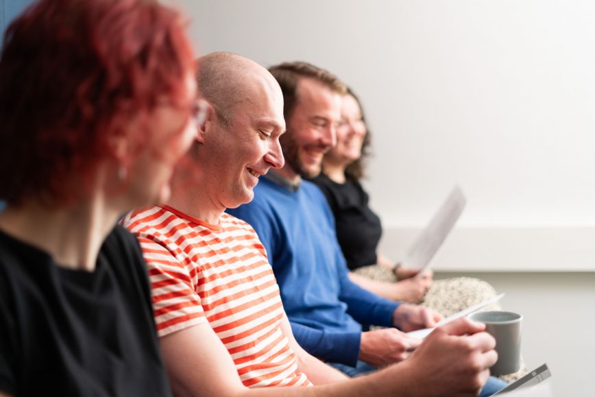 Kuvassa iloisia ihmisiä palaverissa