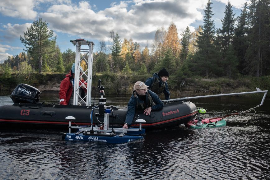 Joella vene, jossa kaksi ihmistä ja erilaisia tutkimuslaitteita