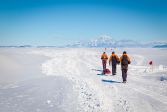 Three people walking in Antarctica.