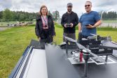 Eija Honkavaara, Teemu Hakala, and Juha Suomalainen in front of a Drone-in-a-box.