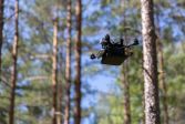 Pienikokoinen drooni lentää metsässä