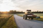 Traktor på landsväg i kvällssol