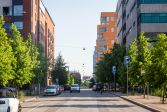  A street with apartment buildings and parked cars along it.
