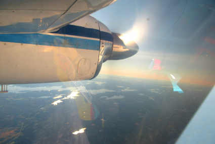Maata ja vesistöä auringonpaisteessa ylhäältä lentokoneesta kuvattuna.