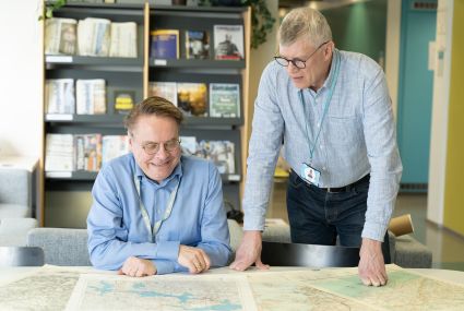 Antti Jakobsson och Jukka Rahkonen tittar på gamla kartor.