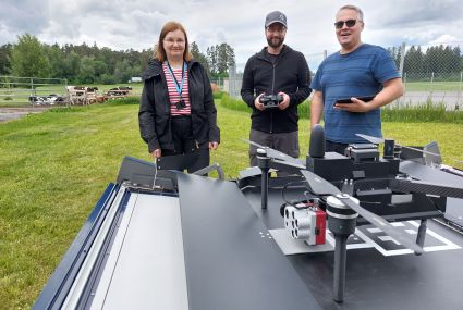 Eija Honkavaara, Teemu Hakala, and Juha Suomalainen in front of a Drone-in-a-box.