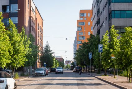  A street with apartment buildings and parked cars along it.